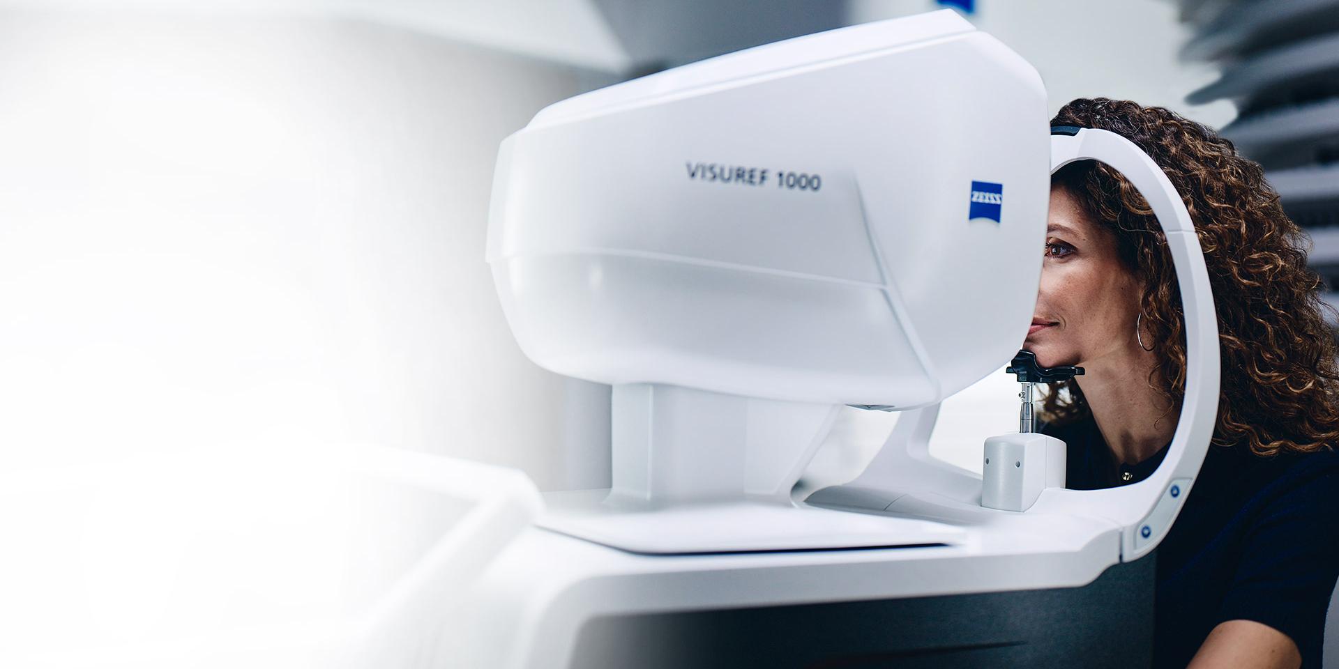 Une femme regarde à travers le ZEISS VISUREF 1000.