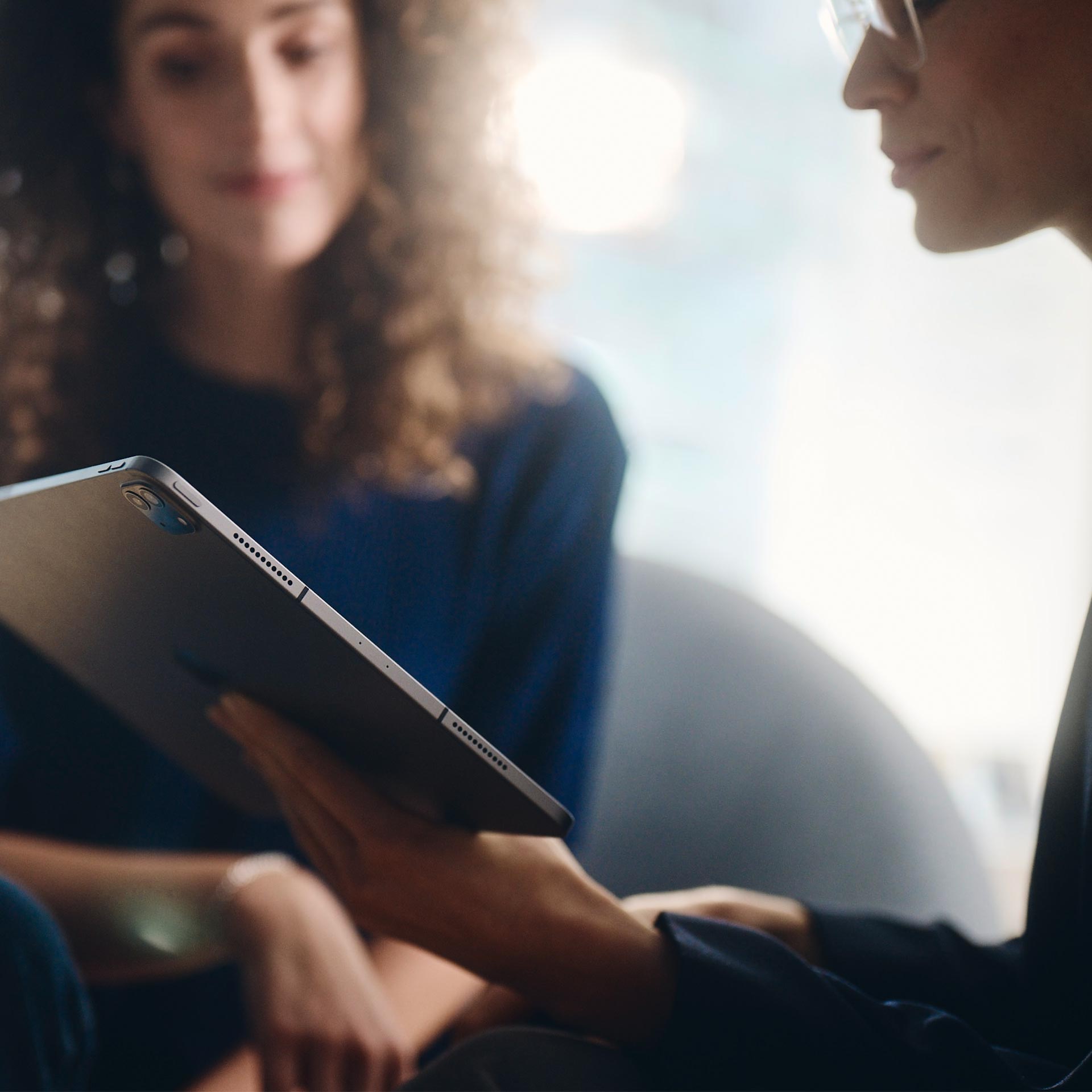 Deux femmes regardent une tablette.