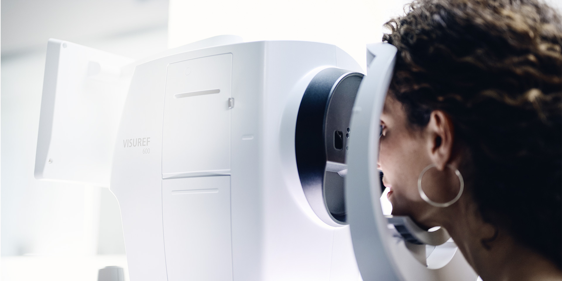 Une femme regarde à travers un ZEISS VISUREF 600