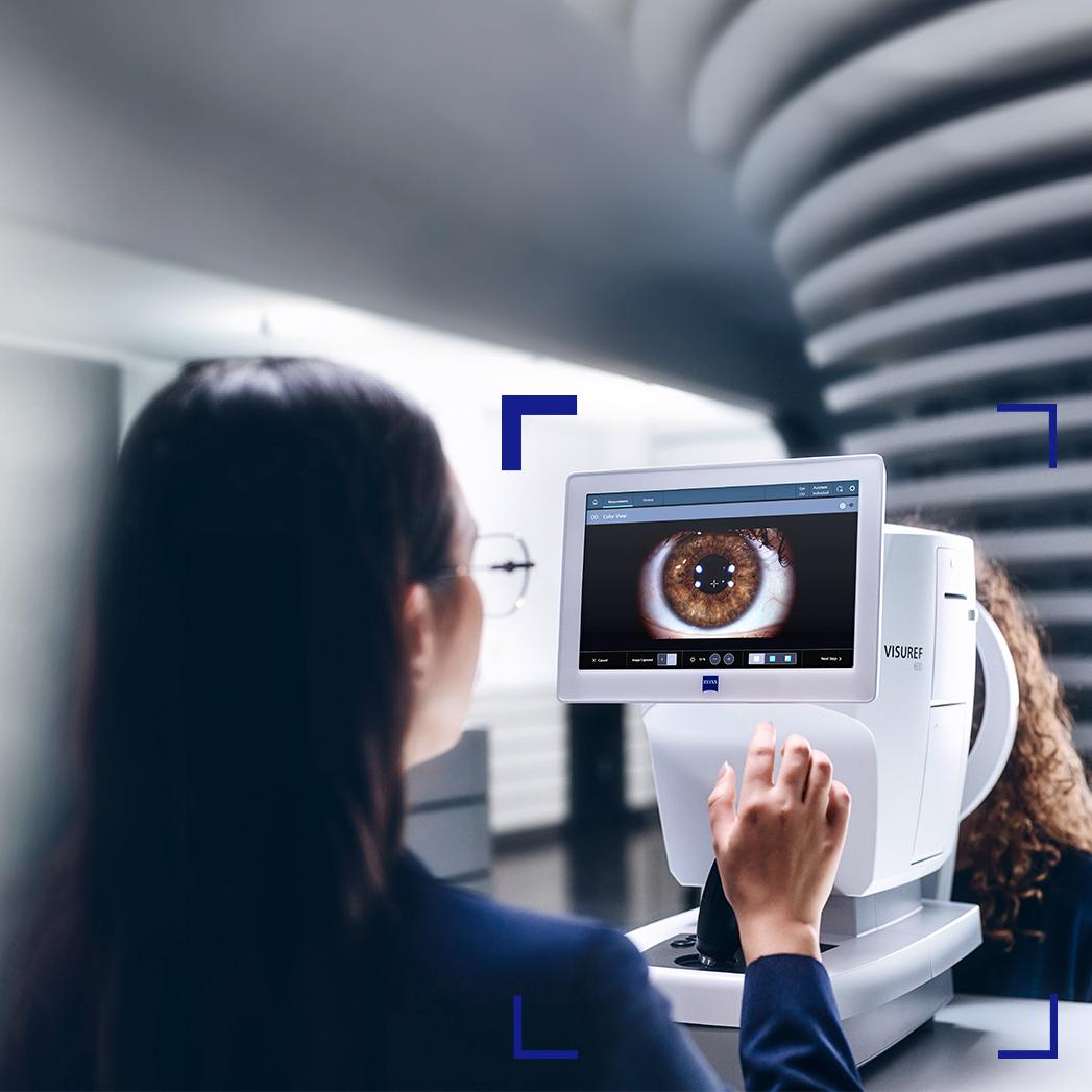 Une opticienne regarde l’écran du ZEISS VISUREF 600 qui affiche l’image d’un œil.