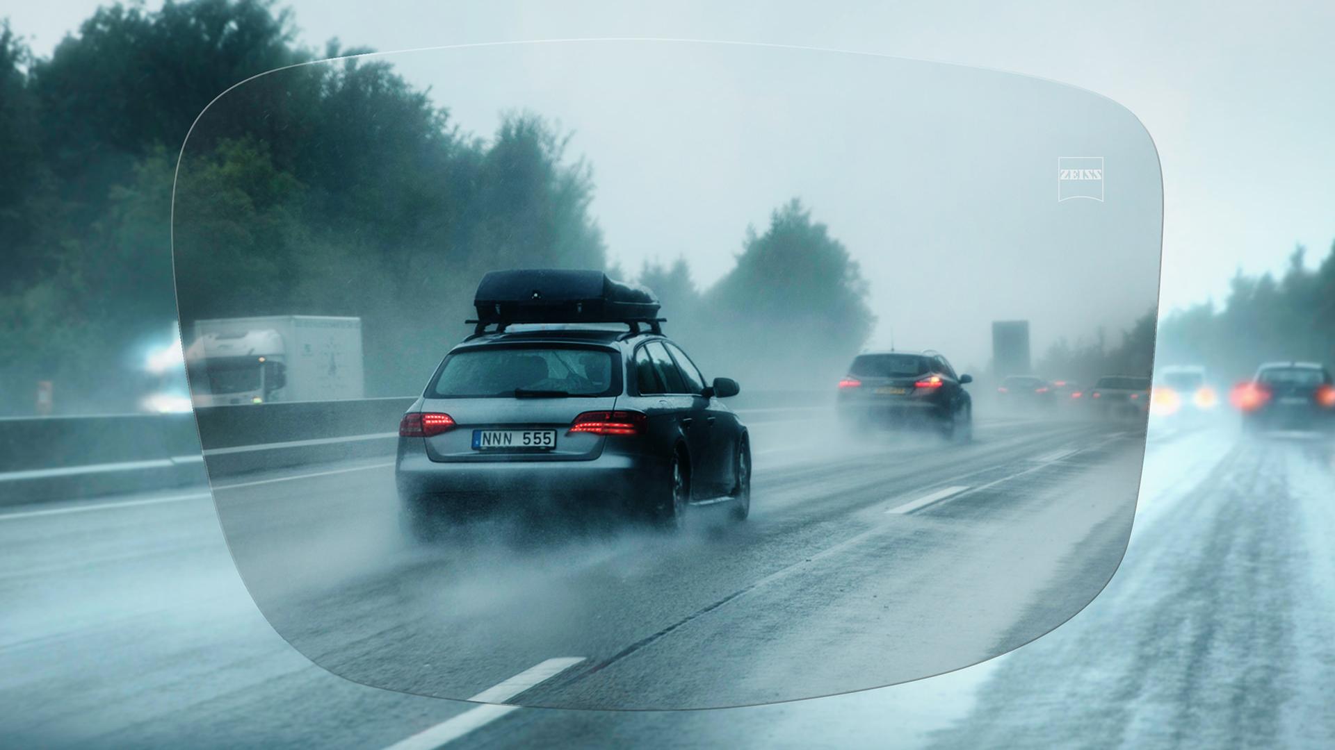 Zicht door een ZEISS enkelvoudig DriveSafe brillenglas op de snelweg op een regenachtige dag 