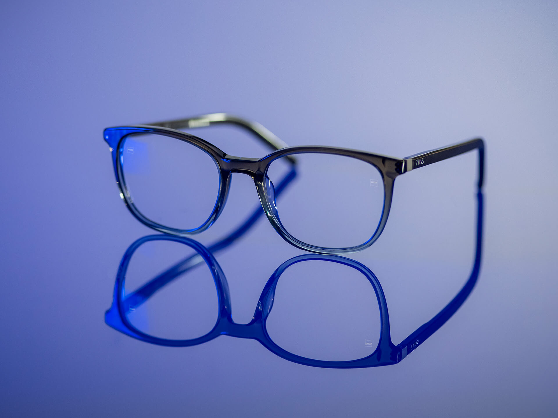 Brillenglazen die zichtbaar zijn in blauwachtig licht en ZEISS brillenglazen met BlueGuard brillenglasmateriaal hebben. Alleen een zeer beperkte blauwachtige reflectie is zichtbaar op de brillenglazen.