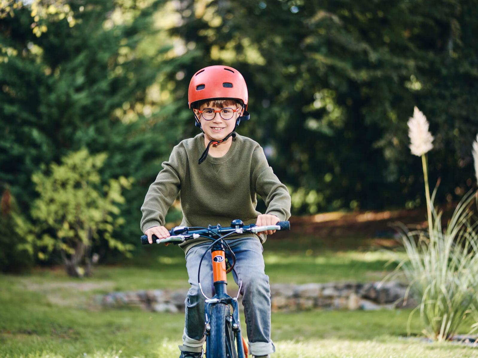 Een jongetje draagt ZEISS brillenglazen voor myopiebeheer buiten op zijn fiets.