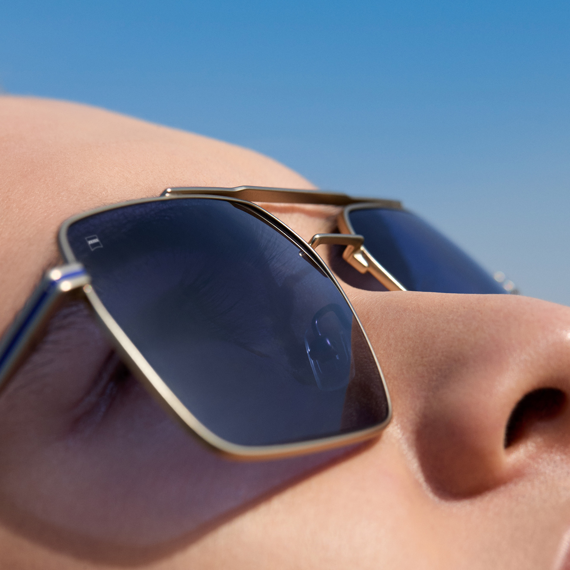 Plan rapproché d’un homme portant des lunettes de soleil correctrices ZEISS à teinte bleu cobalt. 