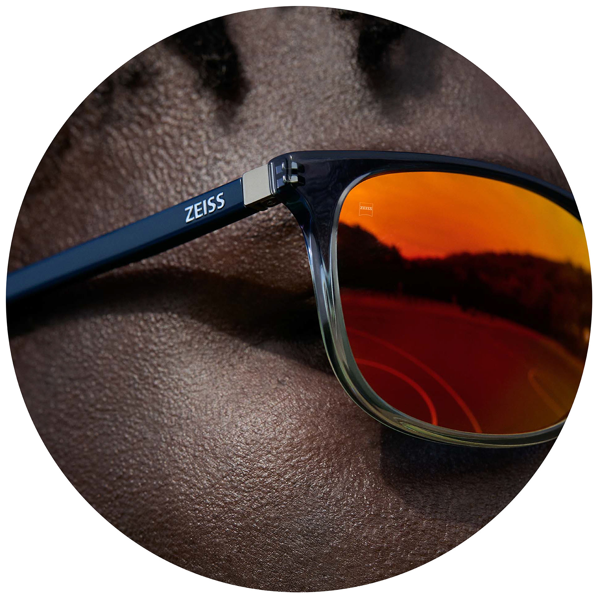 Un homme porte des lunettes correctrices ZEISS avec des verres solaires correcteurs recouverts d’un traitement miroir orange.