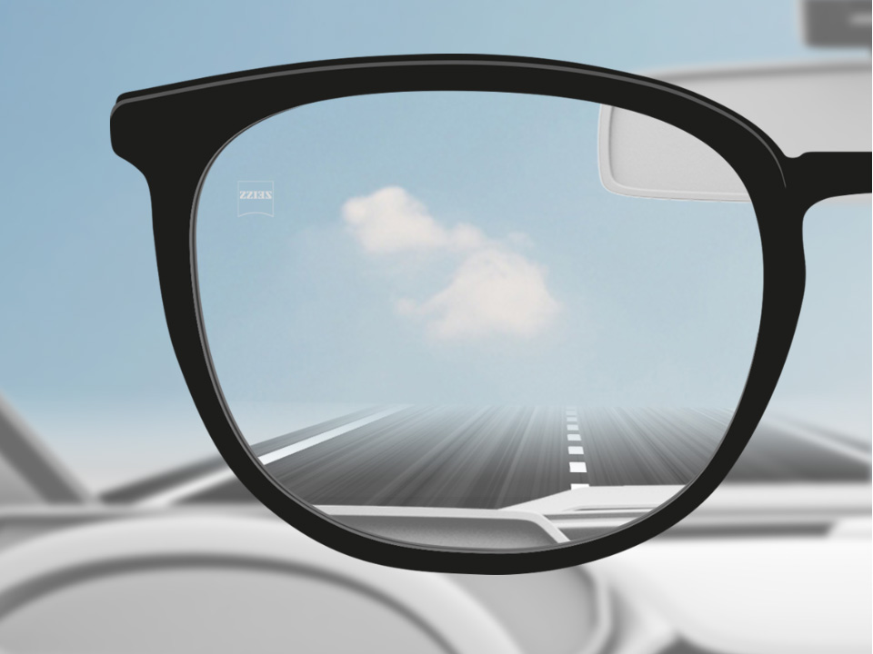 Een point of view-afbeelding van een automobilist met ZEISS unifocale DriveSafe brillenglazen, waarbij het brillenglas volledig helder is. 