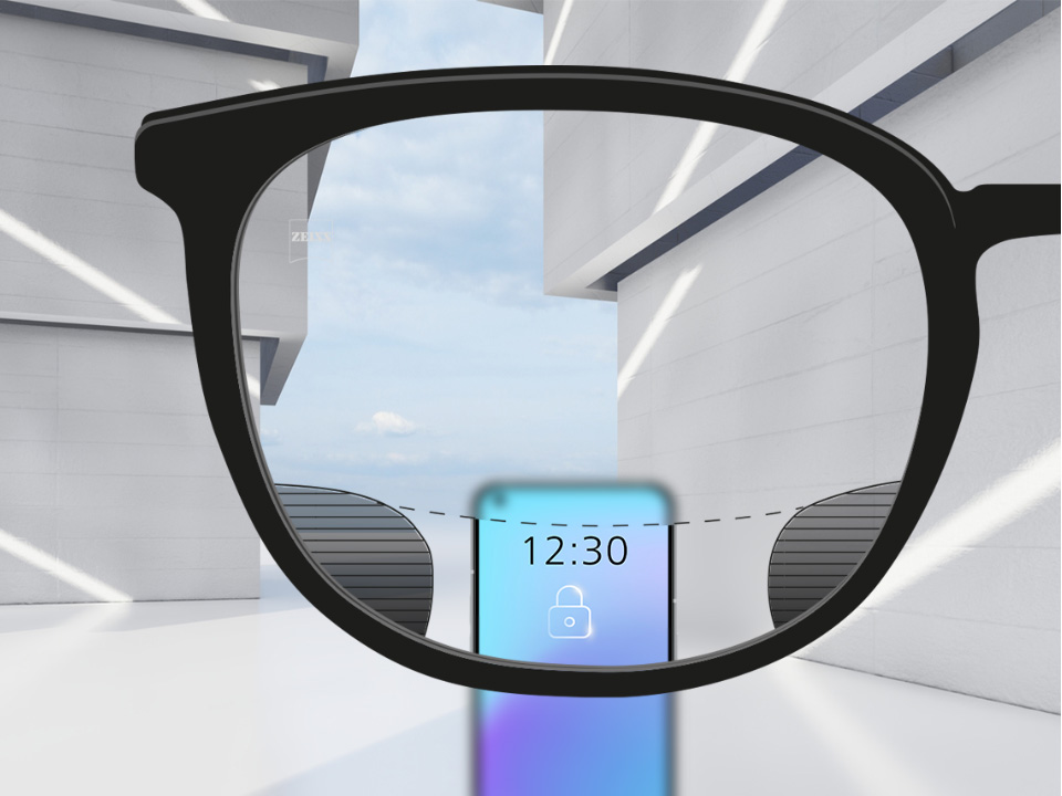 Een point-of-view-beeld met ZEISS Digital SmartLife brillenglazen met een smartphone, waarbij het bovenste en onderste gedeelte van het objectief volledig helder is en  met links en rechts kleine onscherpe percelen. 
