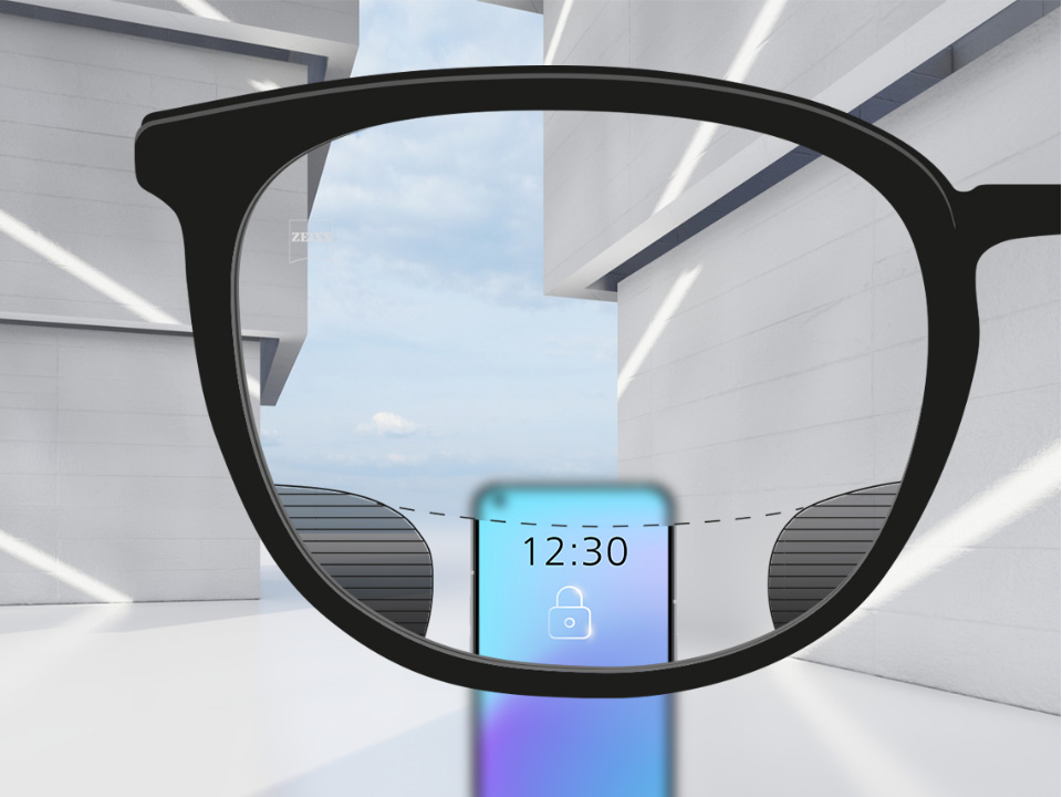 Image montrant à travers un verre ZEISS Digital SmartLife un point de vue sur un smartphone, la vision étant très nette dans la zone supérieure et inférieure du verre et présentant une fine zone floue sur la droite et la gauche.
