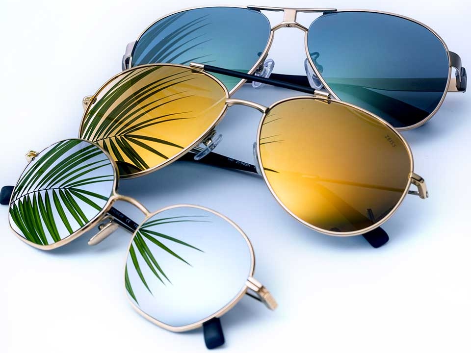 Photo de trois paires de lunettes de soleil avec traitement de verre miroiré de différentes couleurs (transparent, jaune et bleu) 